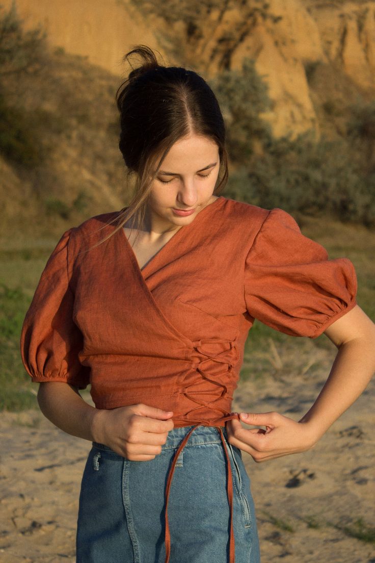 linen blouse, peasant blouse, linen wrap top for women, renaissance tops, linen shirt women, chemise, renaissance shirt A linen top is a stylish and comfortable garment made of light and breathable linen fabric. It has a design where one side of the top wraps around the body to create a flattering V-neck and is secured with laces. This type of top is known for its relaxed and casual chic look, making it a popular choice for casual outings or even semi-formal occasions. The natural texture of the Luxury Cotton Blouse Piece For Designer Wear, Going To Blouses, Cheap Modern Tops With Button Closure, Elegant Spring Dress Shirt, Luxury Elegant Summer Peasant Top, Luxury Cotton Silk Blouse Piece For Designer Wear, Cheap Feminine Daywear Shirt, Linen Casual Dress Blouse, Luxury Cotton Peasant Top For Women