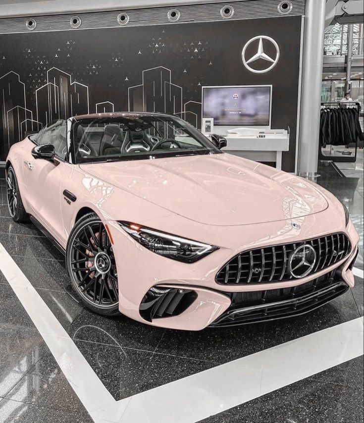 a pink sports car is on display in a showroom