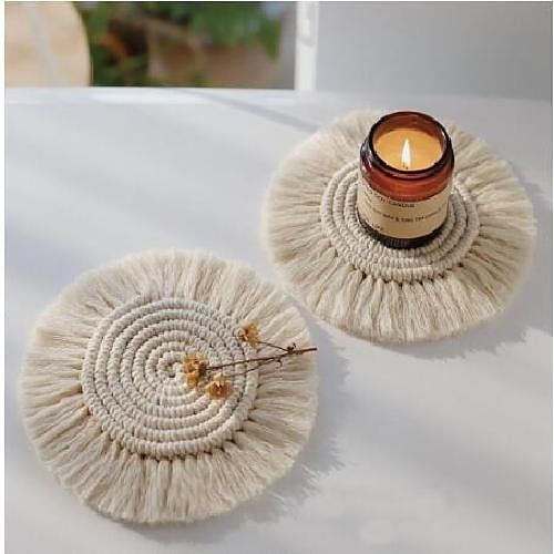 a candle is sitting on top of two coasters that are made out of yarn