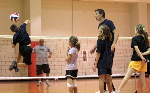 some people are playing volleyball on a court