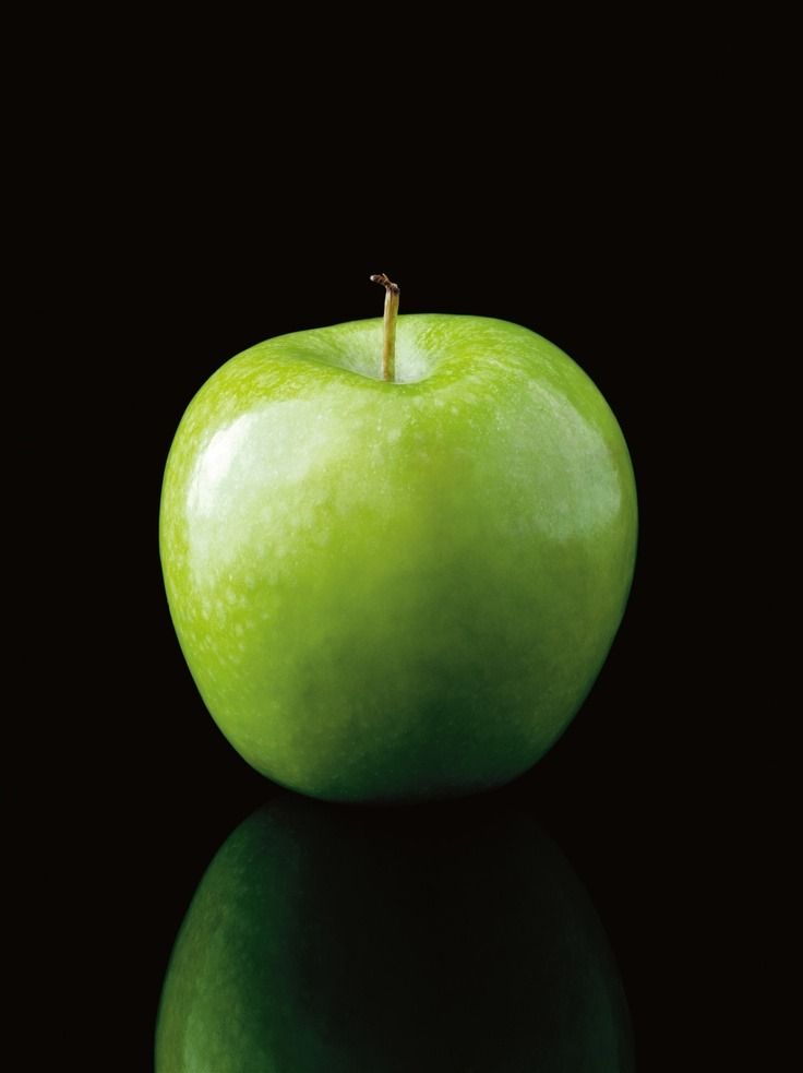 an apple sitting on top of a black surface