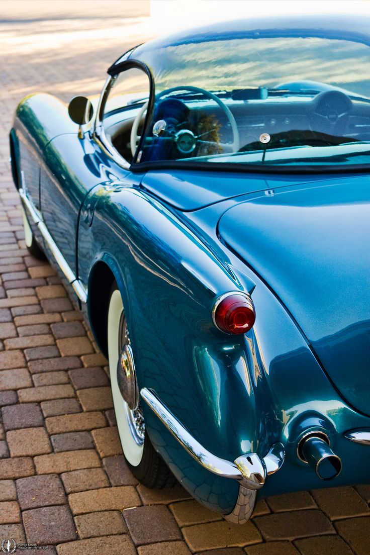 an old blue car is parked on the street