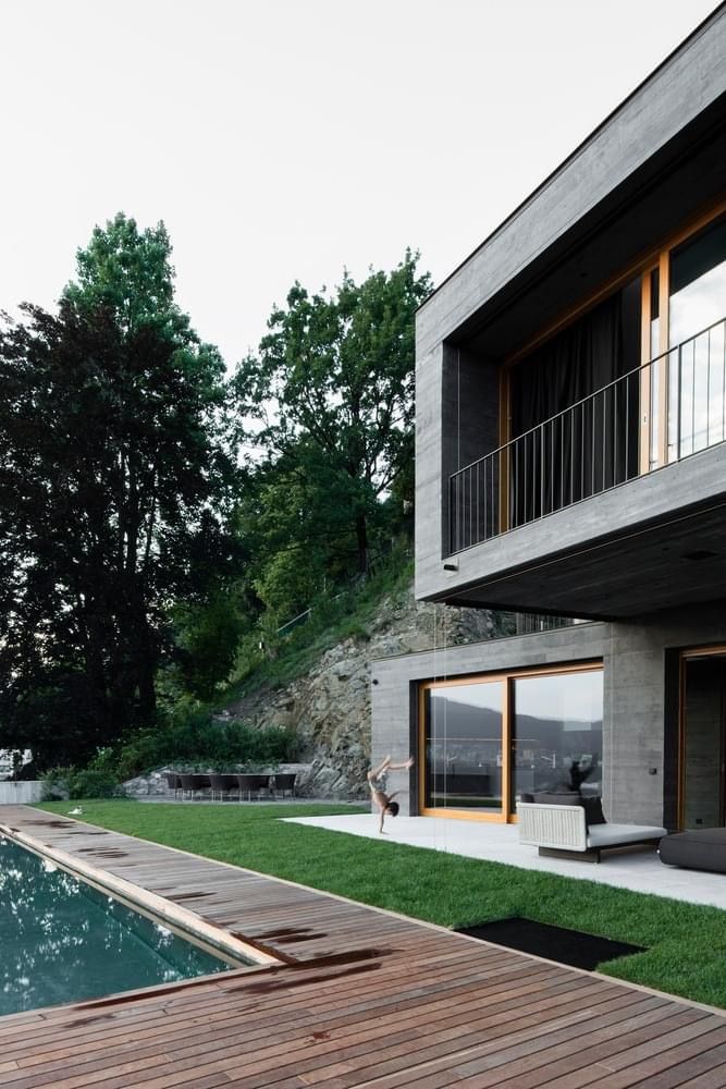 a house with a pool in front of it and some grass on the ground next to it