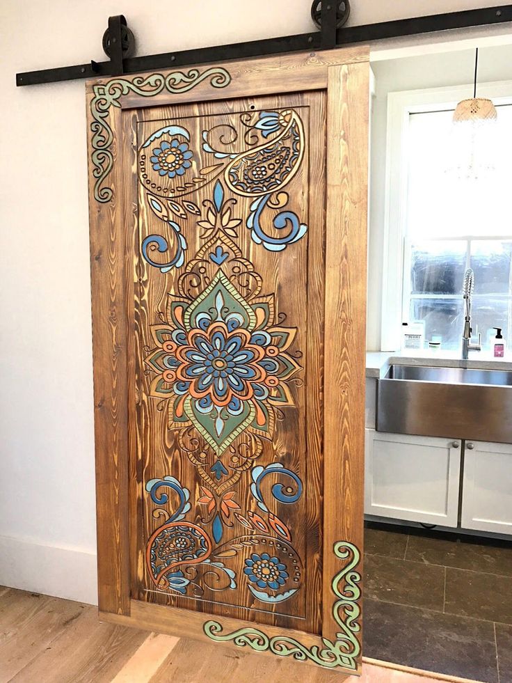 an intricately painted wooden door in a kitchen