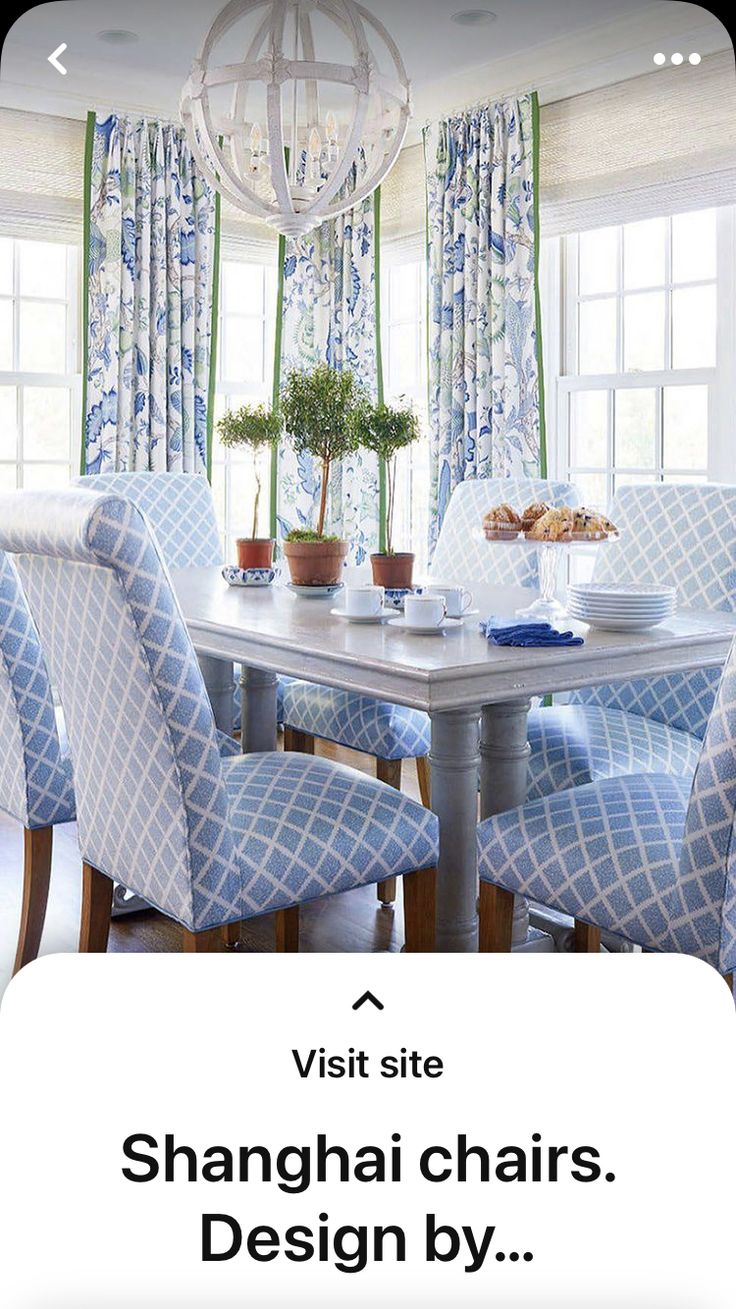 a dining room table with blue chairs and a chandelier hanging from the ceiling