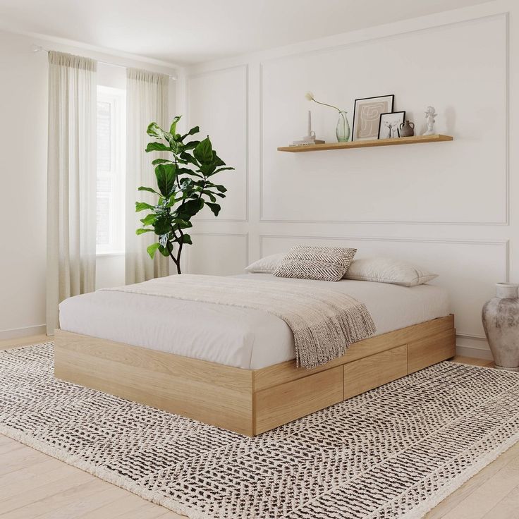 a bed sitting on top of a wooden floor next to a potted green plant