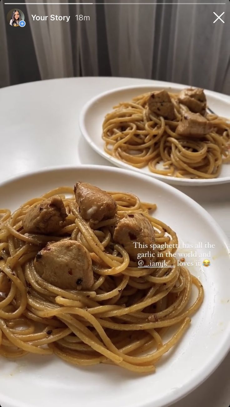 two white plates topped with spaghetti and meat