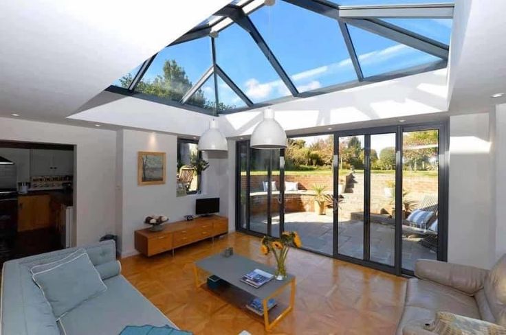 a living room with glass walls and wooden floors