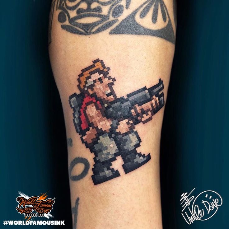 a man's arm with an old school style video game character tattoo on it