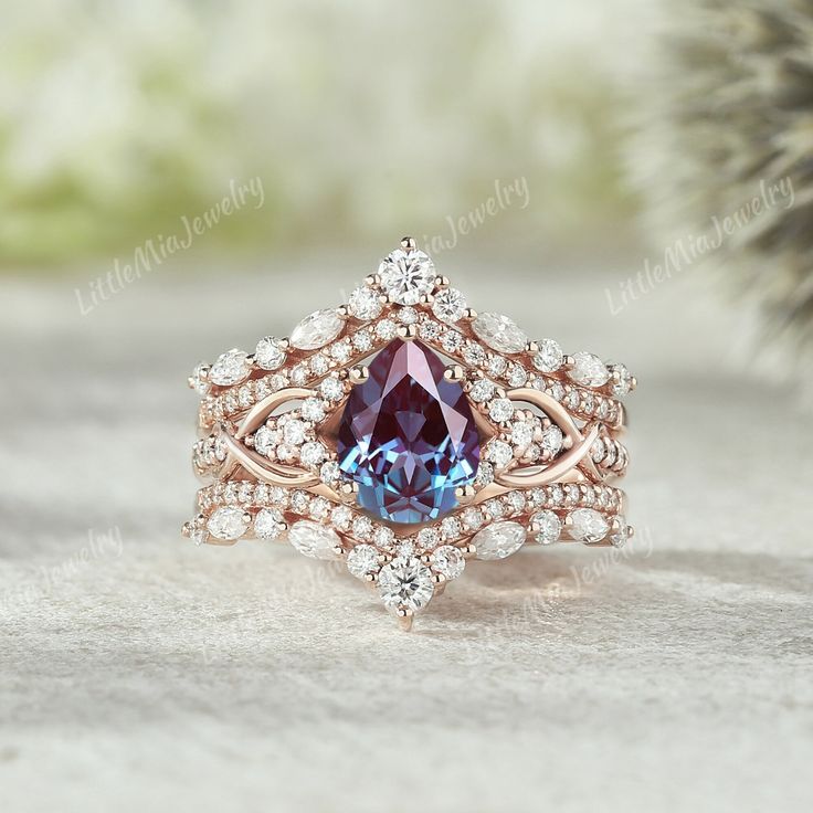 a ring with a blue stone surrounded by white and pink diamonds on top of it