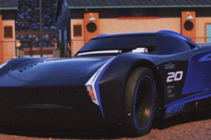 a black and blue race car parked in front of a building