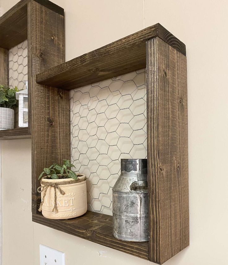 two wooden shelves with pots on top of them and one shelf holding some plants in it