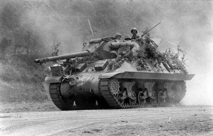 an old tank driving down a dirt road