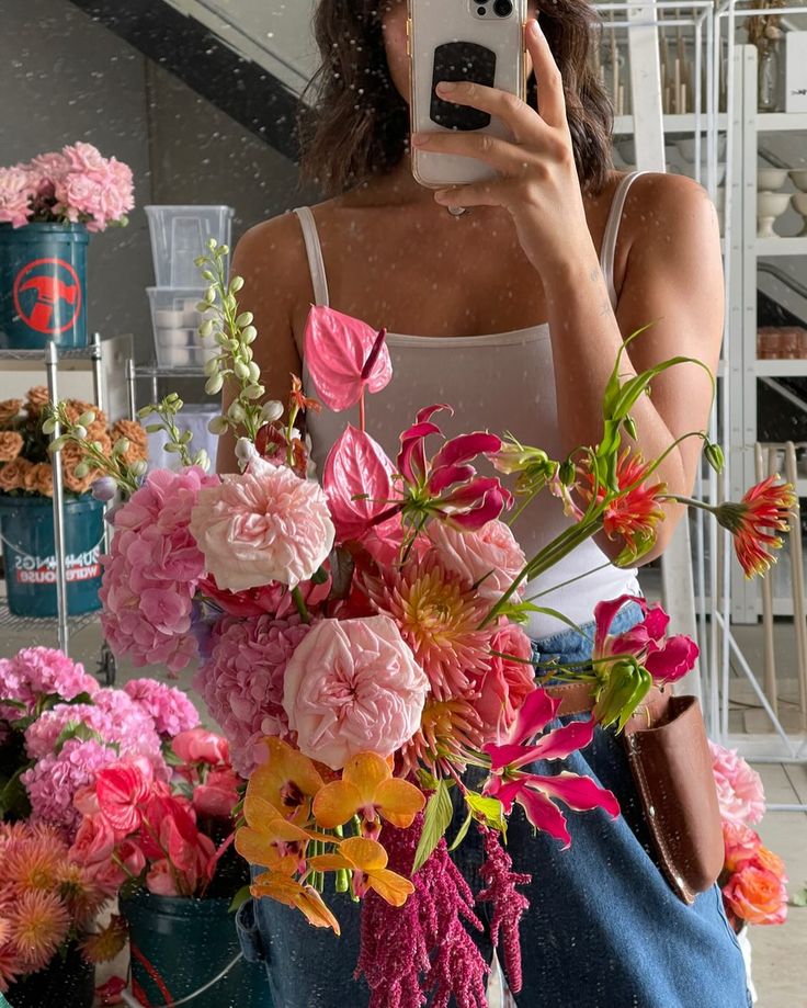 a woman taking a selfie in front of flowers