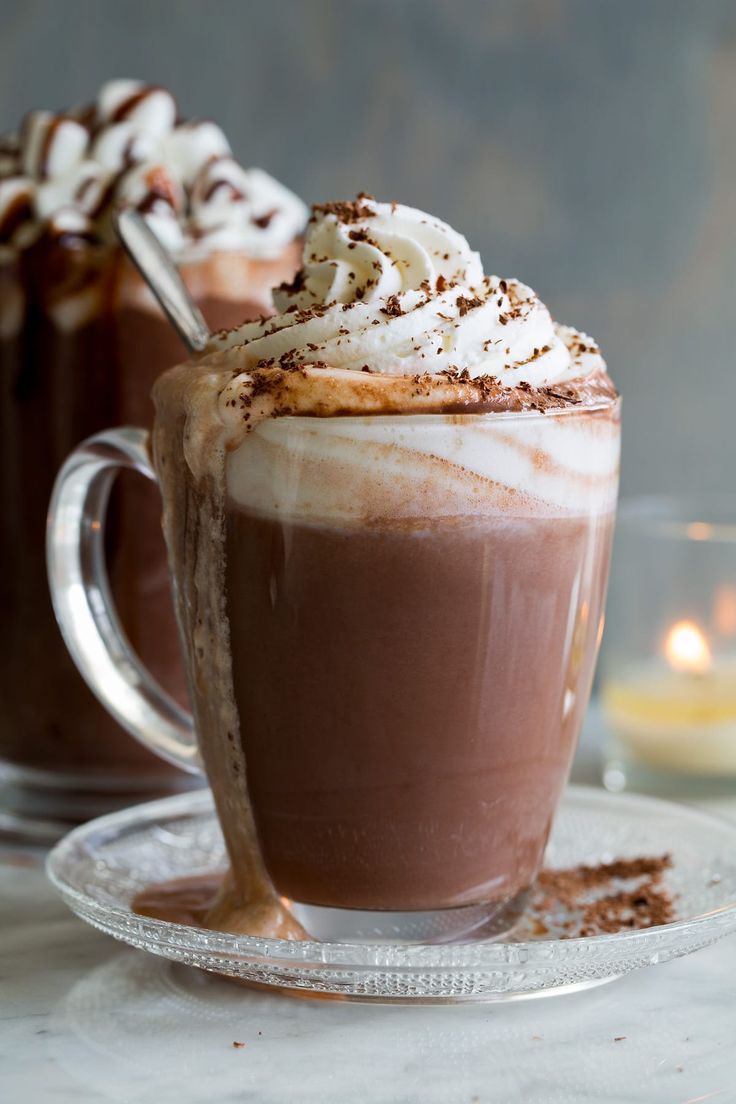 two cups filled with hot chocolate and whipped cream