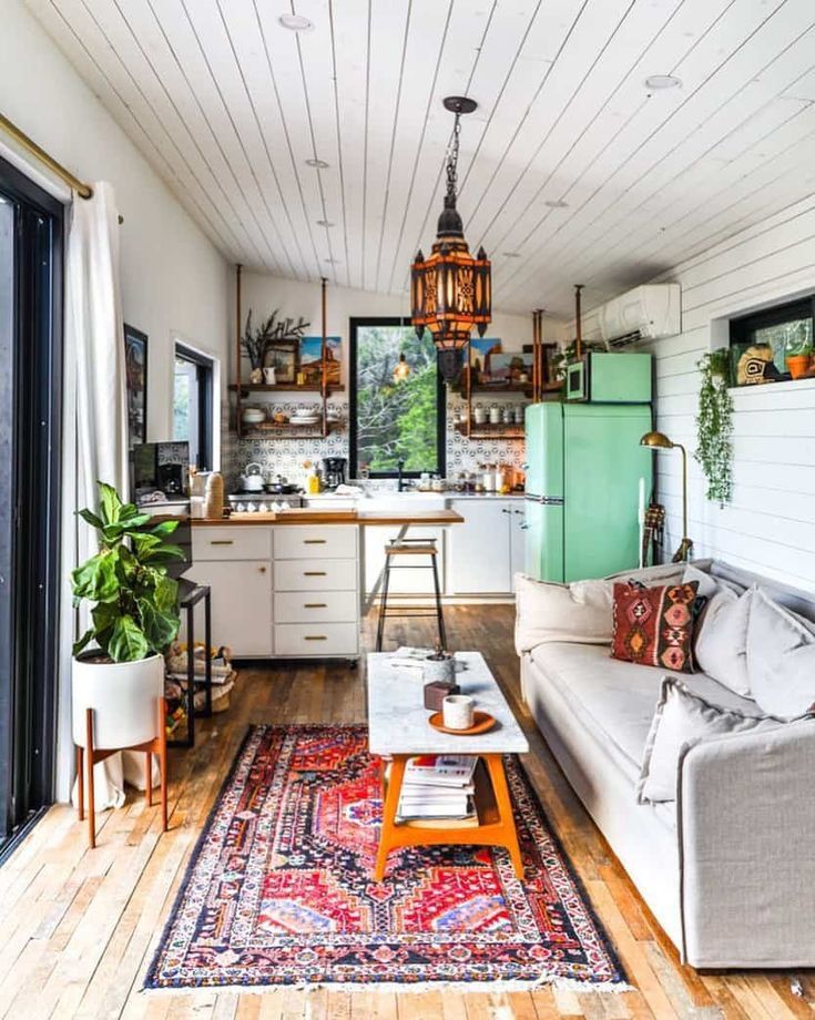 a living room filled with furniture next to a kitchen