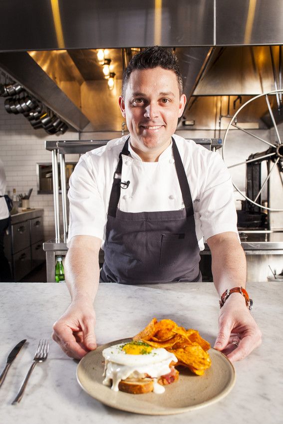 a man in an apron is preparing food on a plate