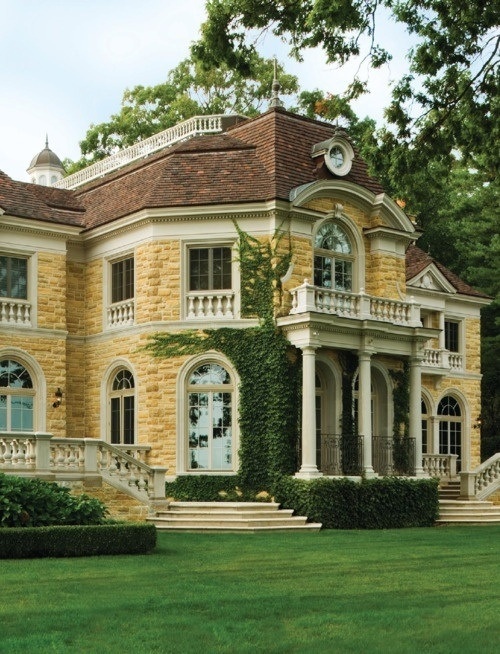 a large yellow brick house with many windows and balconies on the second floor