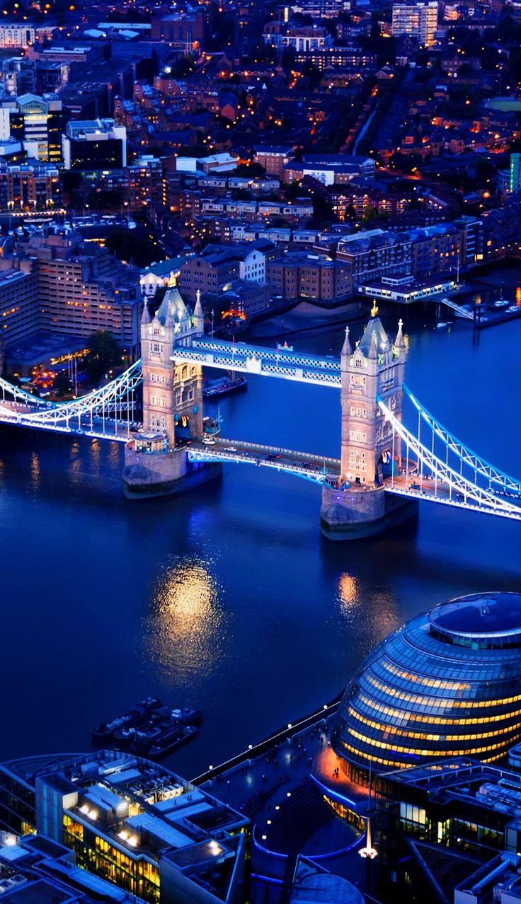 an aerial view of the london skyline at night with tower bridge in the foreground