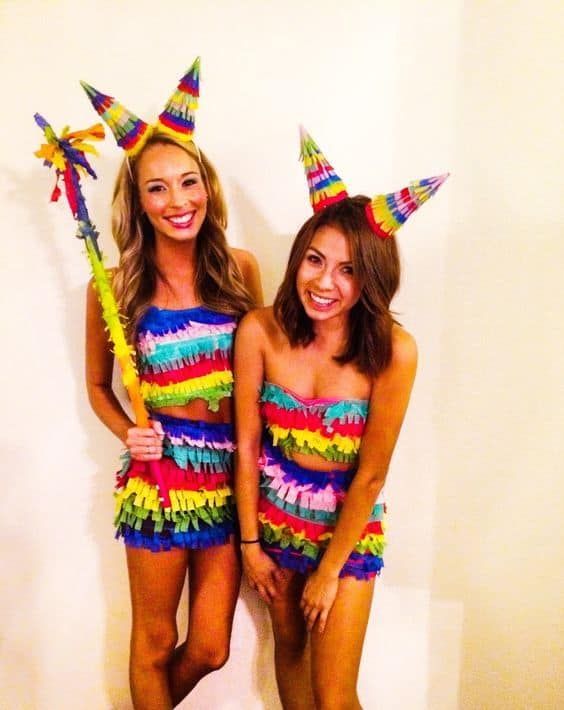 two beautiful young women standing next to each other wearing colorful outfits and holding pinwheels