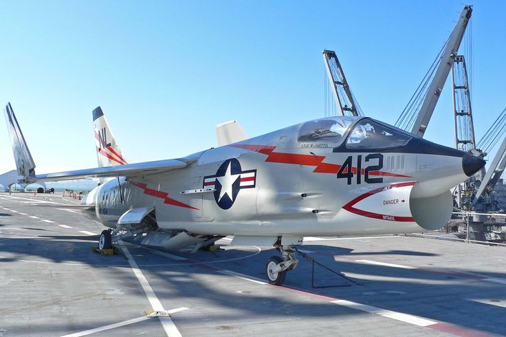 a fighter jet sitting on top of an airport tarmac next to other aircrafts