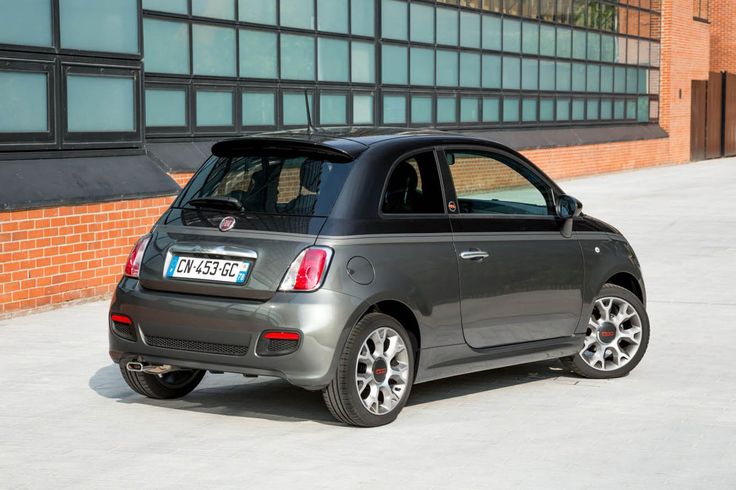 a small gray car parked in front of a building