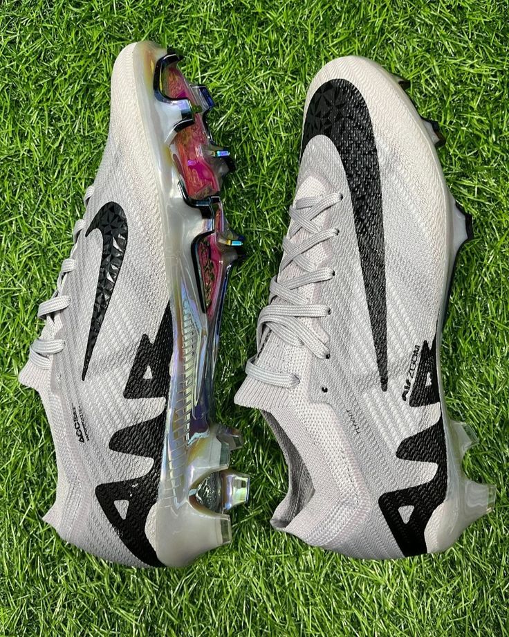 a pair of white and black sneakers on green grass in the sun, top view