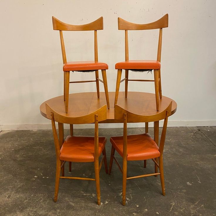 three wooden chairs sitting on top of a table