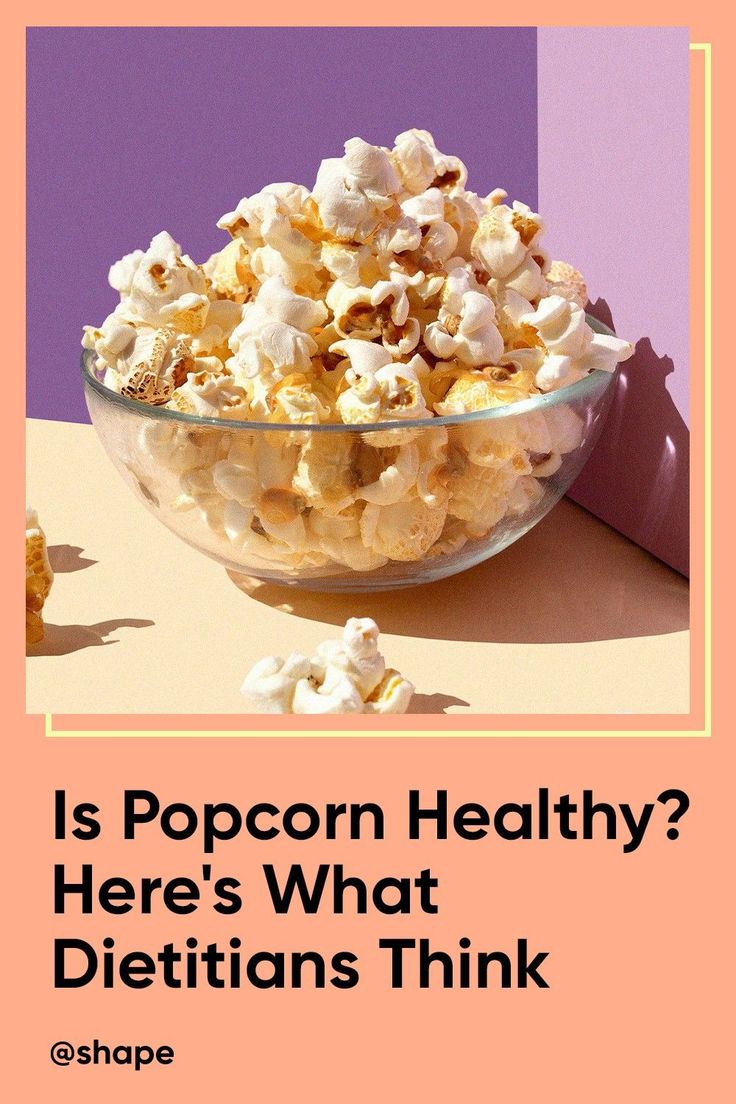 a bowl filled with popcorn sitting on top of a table next to a purple and pink background