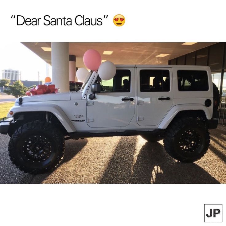 a white jeep parked in front of a building with balloons attached to the roof and windows