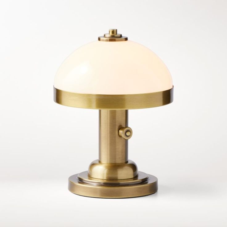 a brass table lamp with a white glass shade