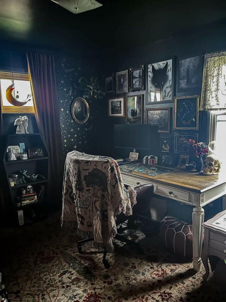 an old fashioned desk and chair in a dark room with pictures on the wall behind it