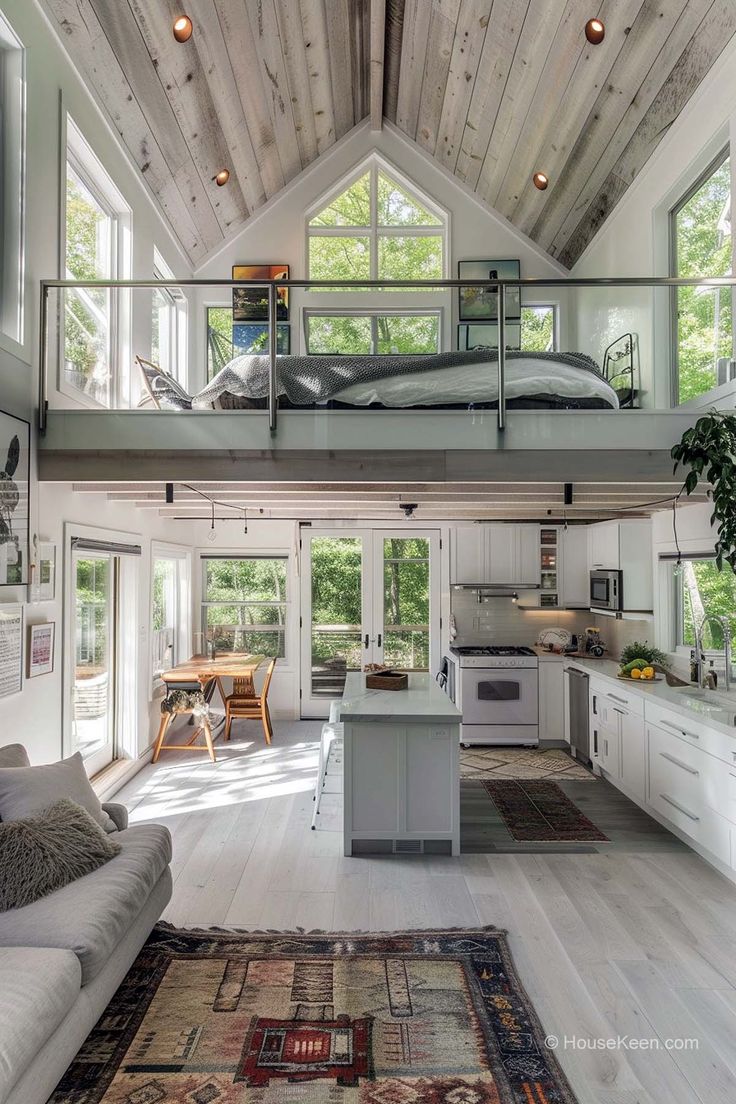 an open floor plan with white walls and wood ceilinging in a loft style home