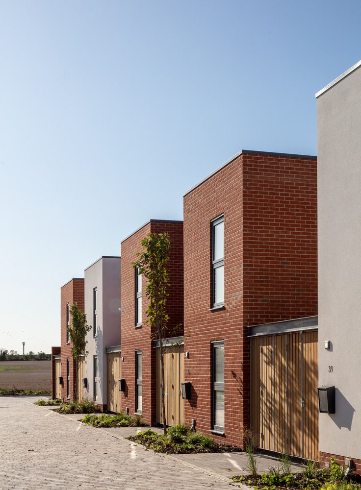 a row of brick buildings sitting next to each other on top of a dirt field