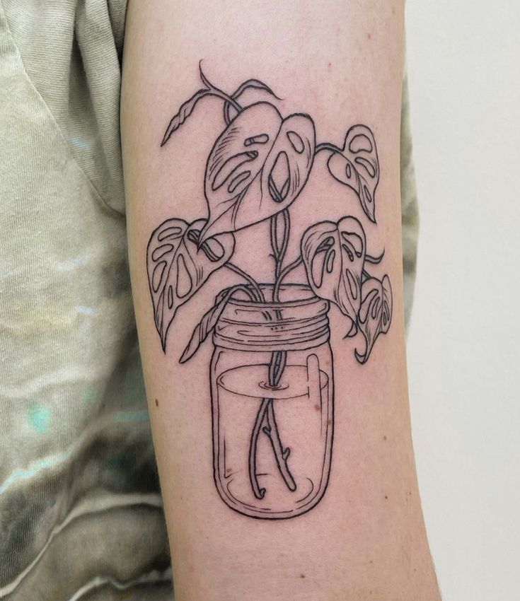 a black and white drawing of a plant in a jar on the left upper arm