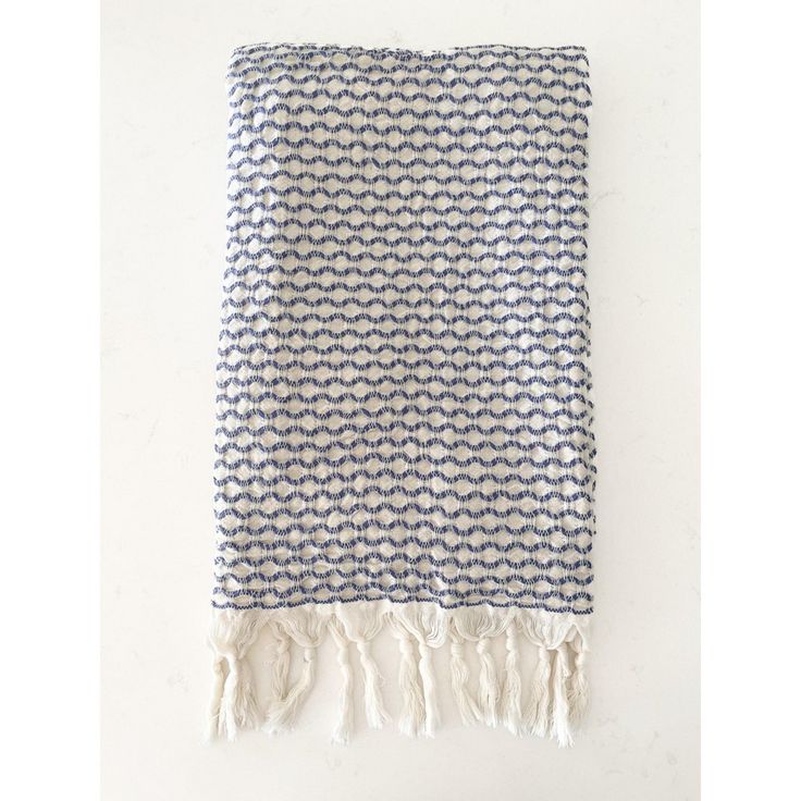 a blue and white blanket with fringes on it