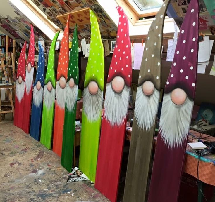 several wooden gnomes are lined up next to each other in the shape of snowboards