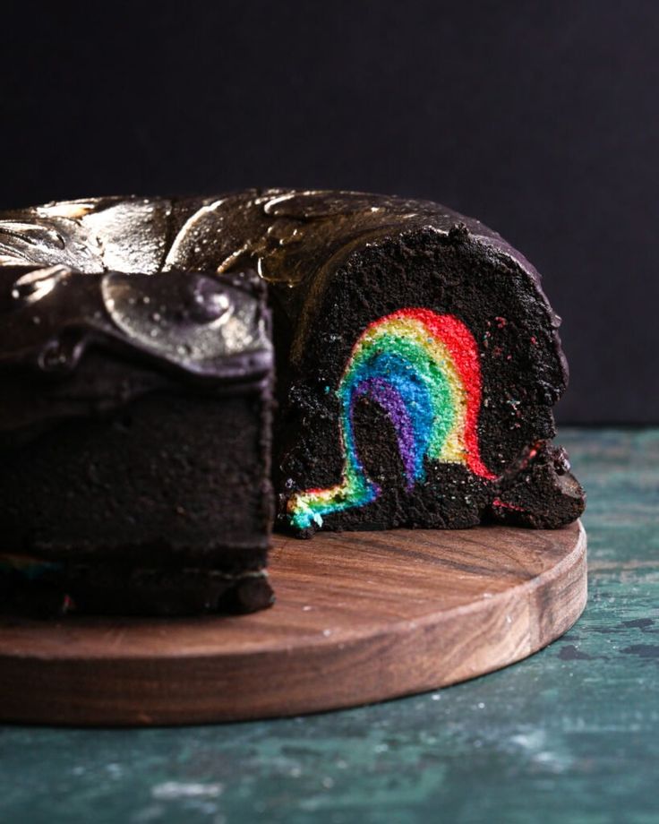 a slice of chocolate cake with a rainbow painted on the side and one piece missing