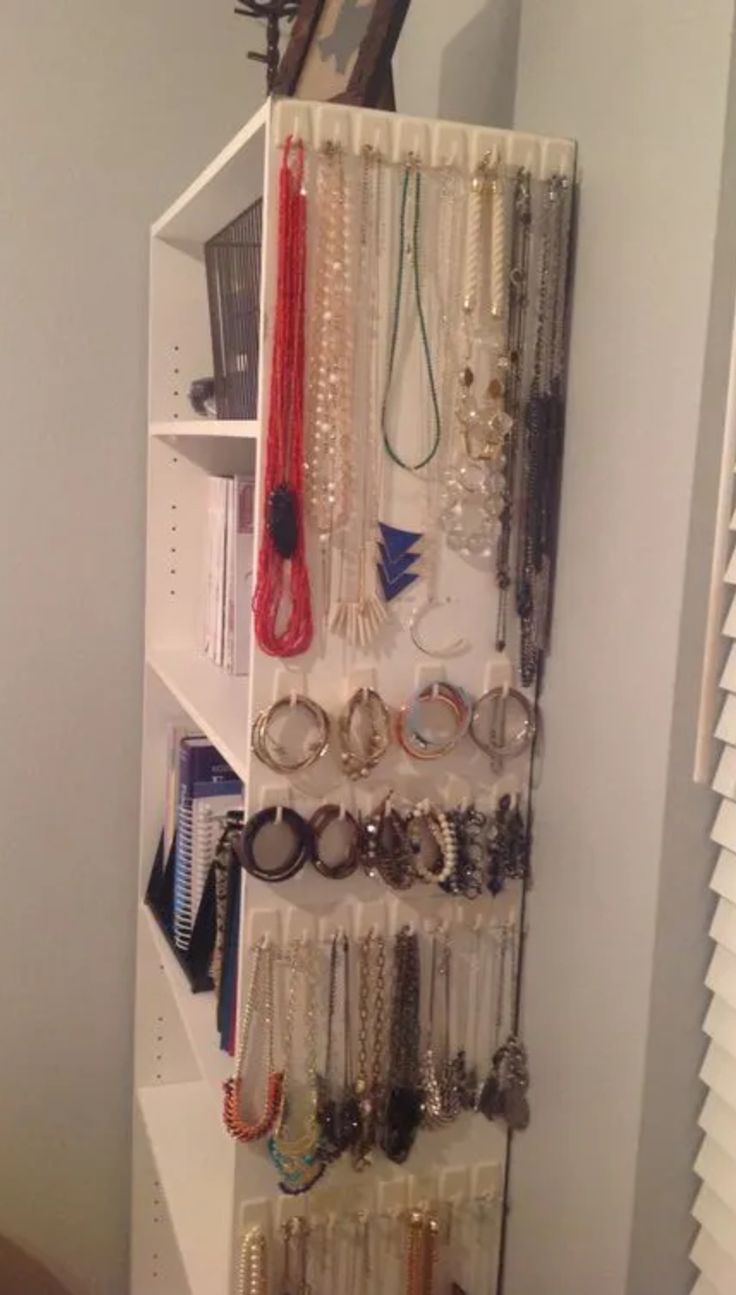 a white shelf filled with lots of jewelry