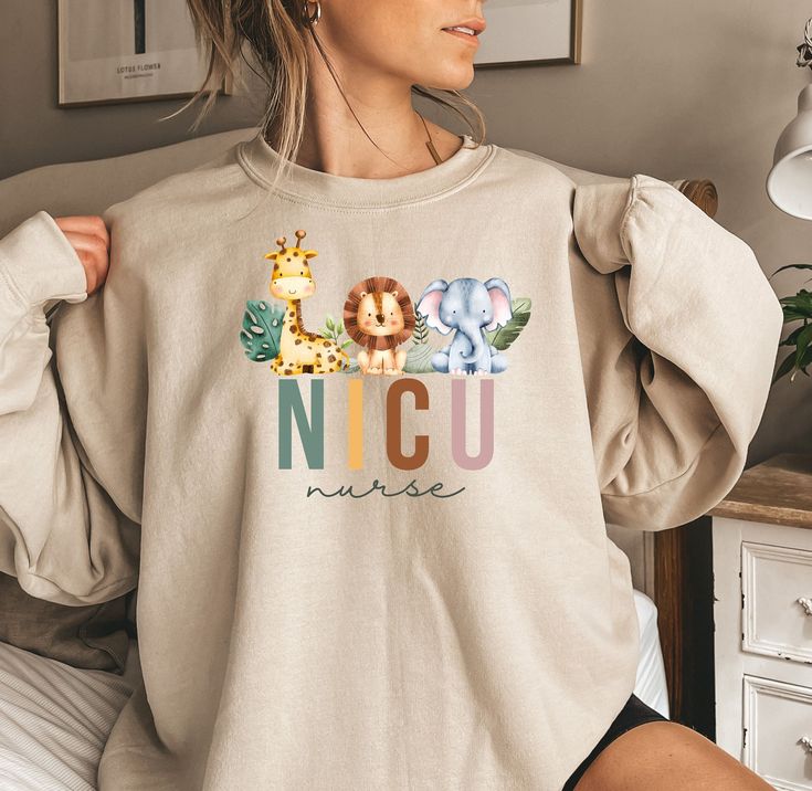 a woman wearing a sweatshirt with the word nicu on it and two giraffes