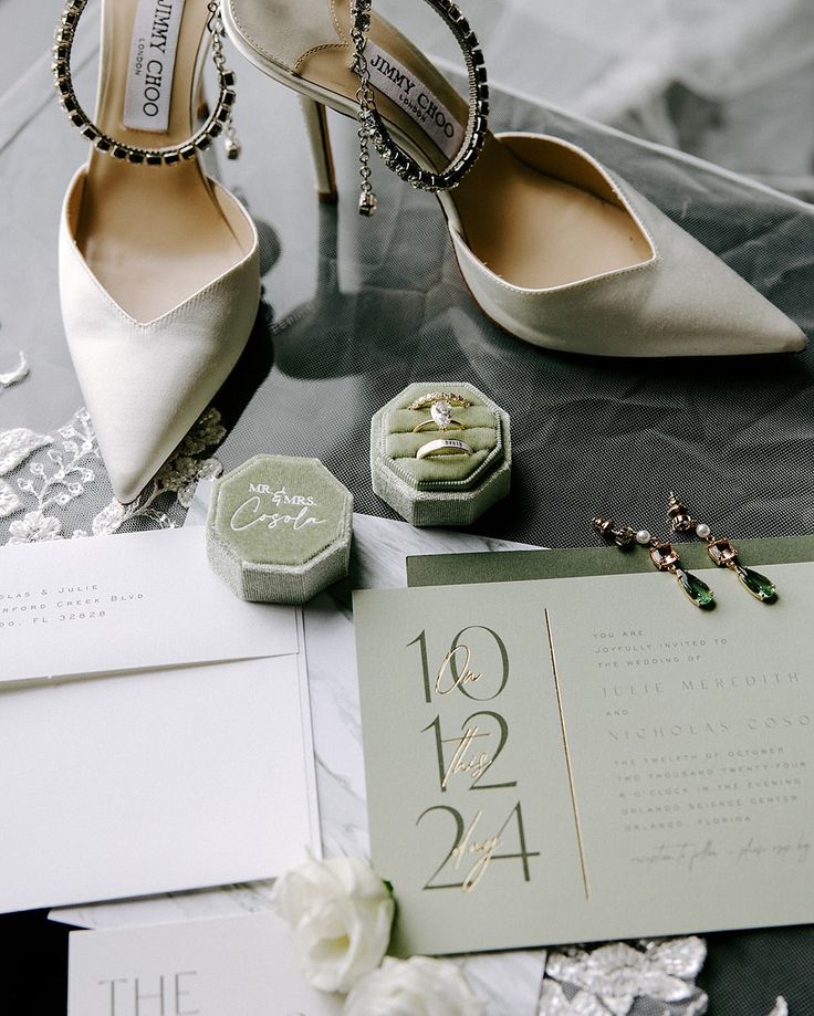 the wedding shoes are on top of the table next to the card and brochure