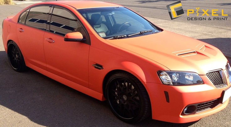 an orange car is parked on the street