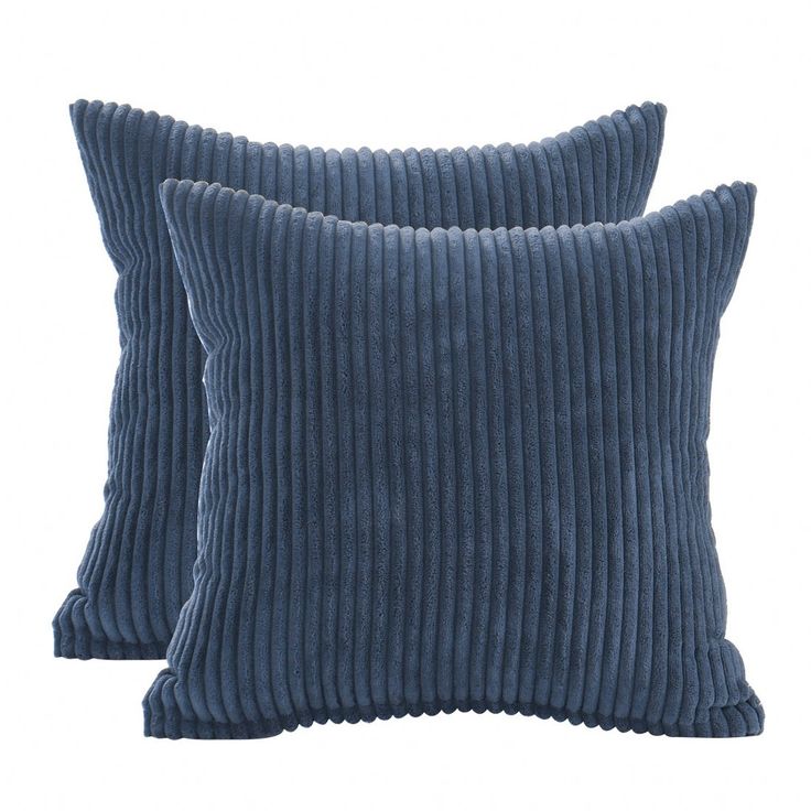 two blue velvet pillows sitting on top of each other