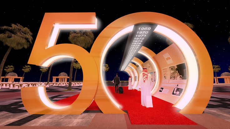 a woman is walking down the red carpet in front of an illuminated sign that reads 50