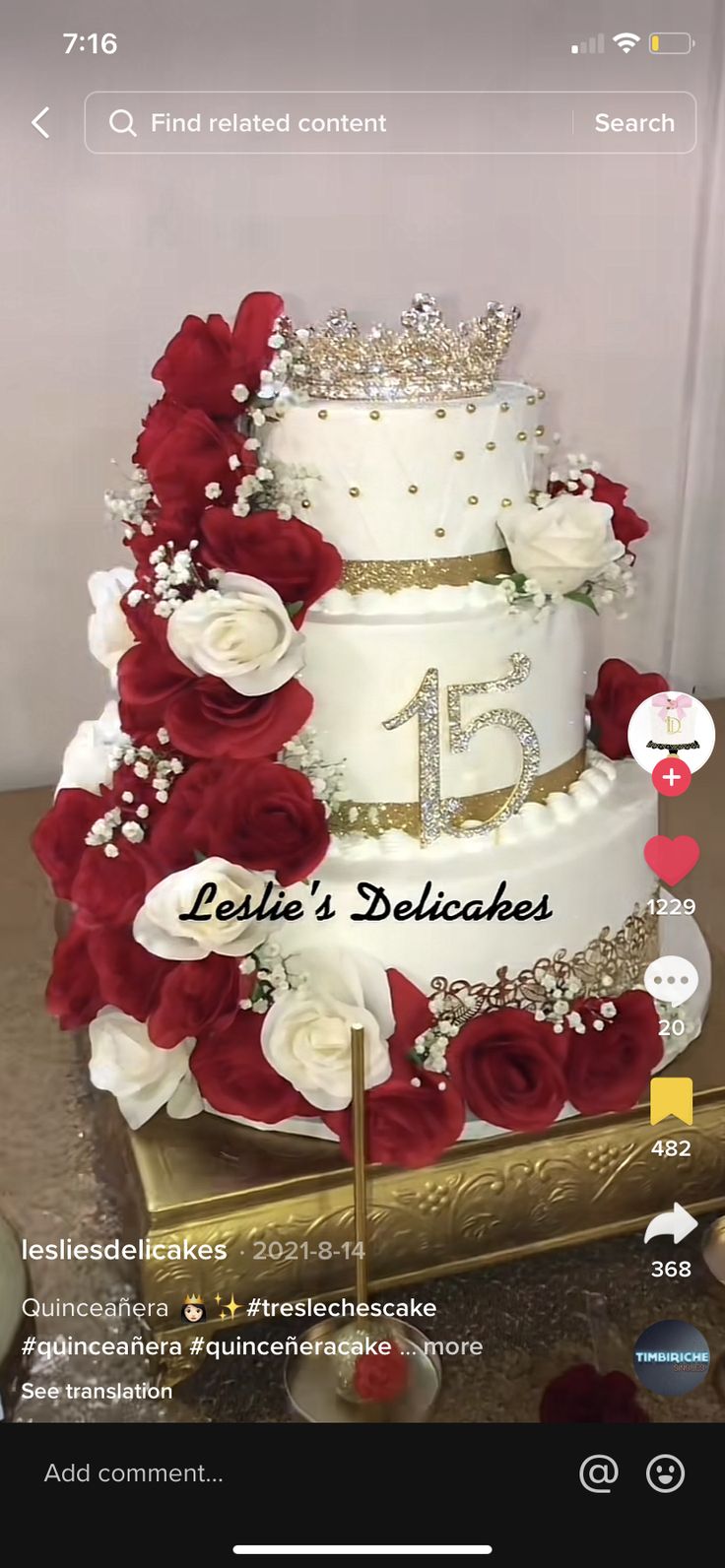 a three tiered wedding cake with red and white flowers on top, surrounded by gold trimmings