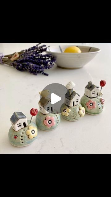 a group of little houses sitting on top of a table next to a bowl of lemons