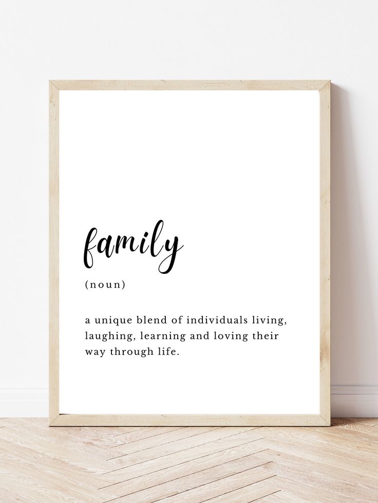 a framed print with the words family in black and white on it, against a wall