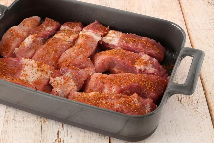 some meat in a pan on a wooden table