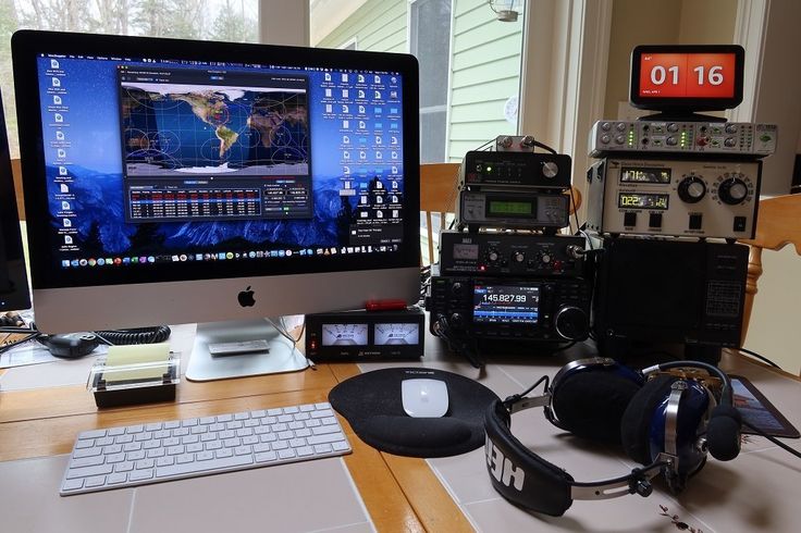 a computer monitor sitting on top of a desk next to headphones and other electronics