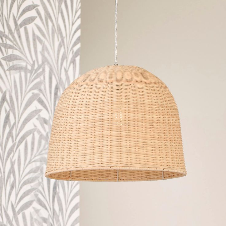 a wicker lamp hanging from the ceiling in front of a wallpapered background